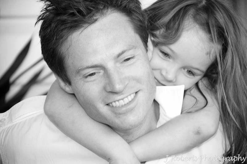 Daughter hugging father around the neck - family portrait photography sydney